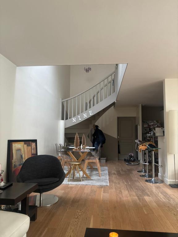 un salon avec un escalier et une table dans l'établissement Maison de ville - versailles château, à Versailles