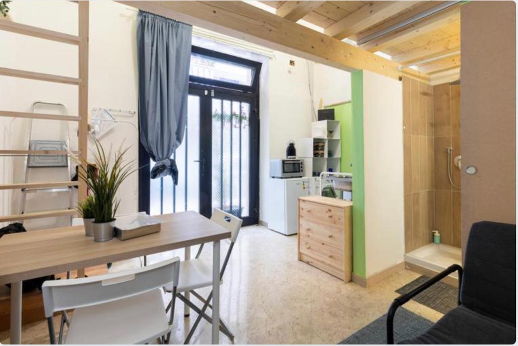 une chambre avec une table à manger et une chambre avec une cuisine dans l'établissement Little Loft 14 appartamento vicino il centro di Bari, à Bari