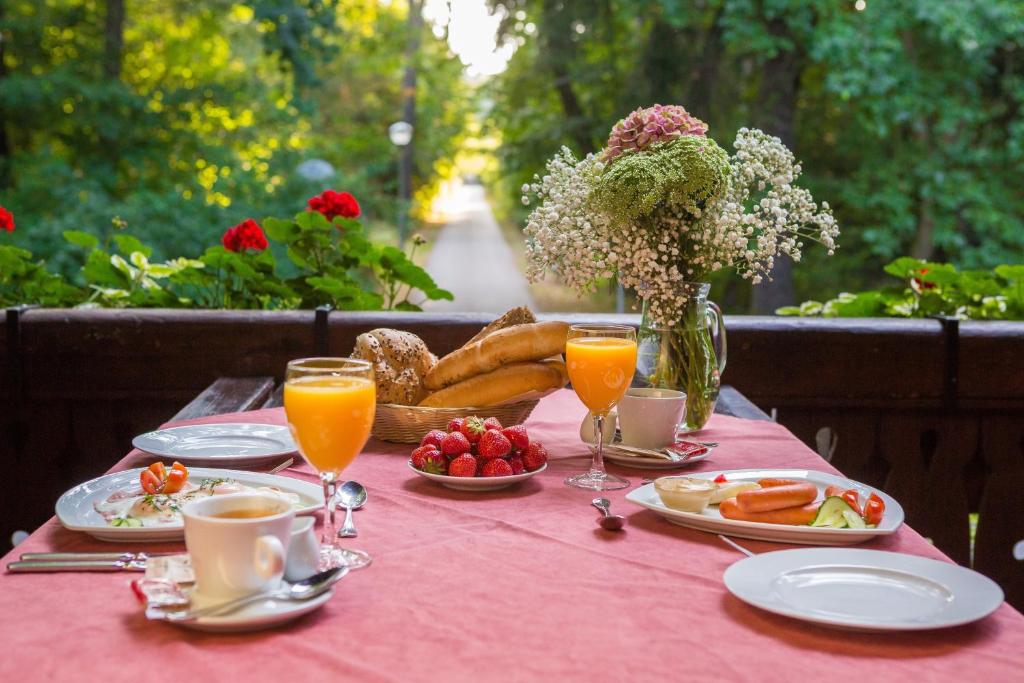 una mesa con un mantel rosa con comida y bebida en Penzion Obora, en Poděbrady