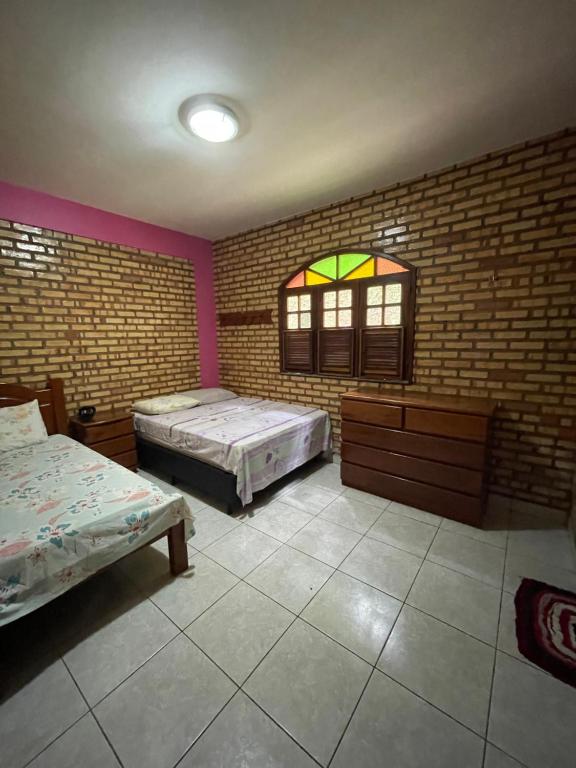 a large room with two beds and a window at Casa na serra de mulungu in Mulungu