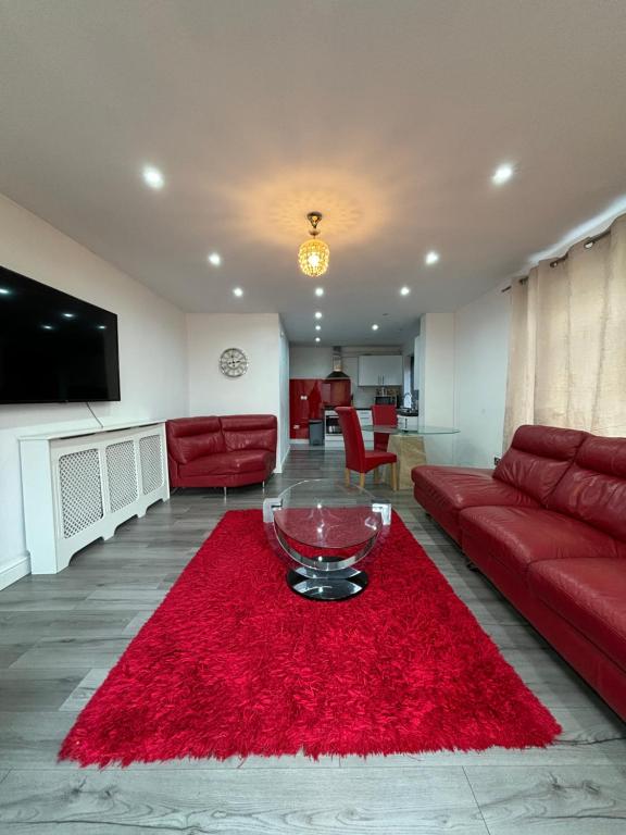 a living room with a red couch and a red rug at Cheerful 2 Bedroom Bungalow fully Furnished in Bradenham