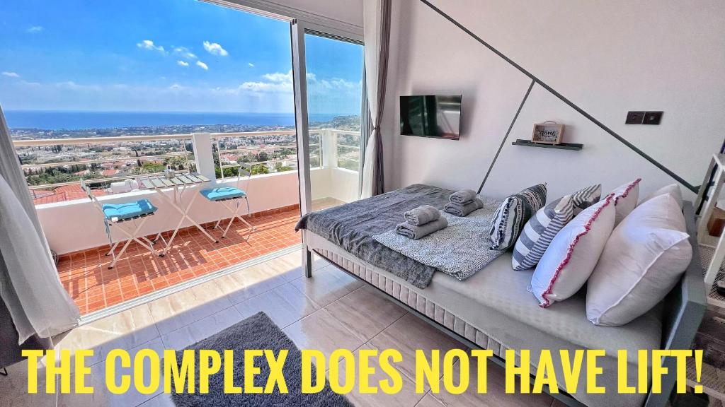 a bedroom with a bed with a view of the ocean at PMP Adamia Apartments in Peyia