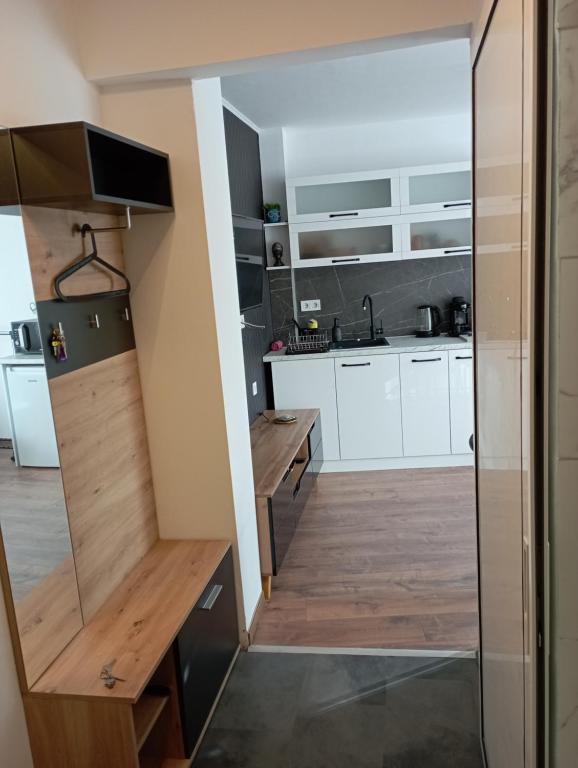 a kitchen with white cabinets and a wooden counter at Студио за нощувки Габрово in Gabrovo