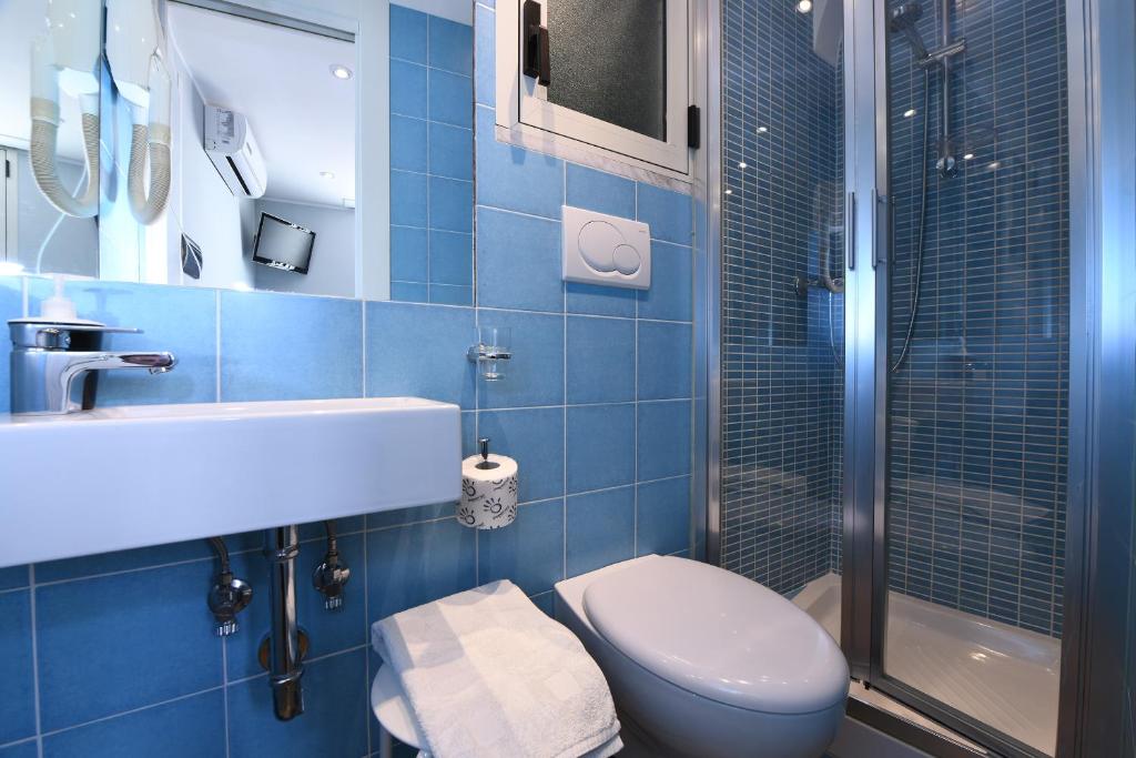 y baño de azulejos azules con aseo y ducha. en La stanza sul Porto di Amalfi camera piccina piccina con bagno privato en Amalfi