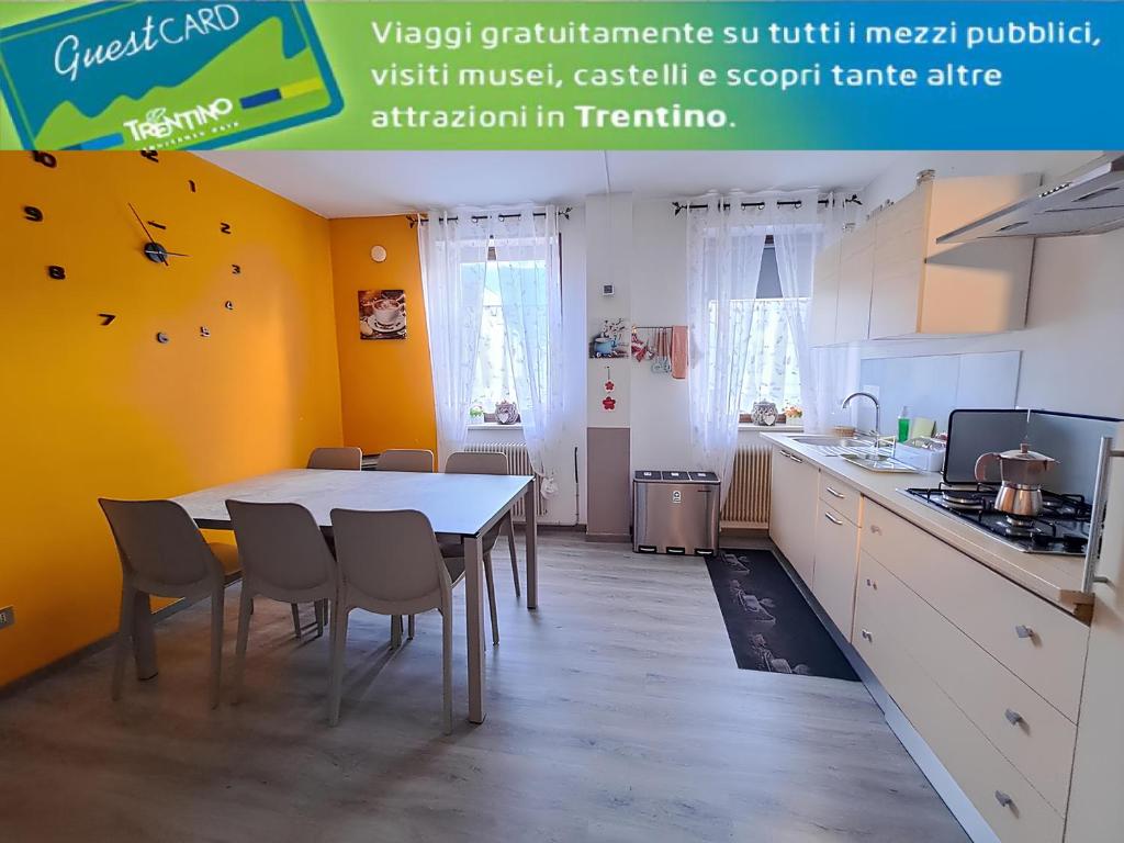 una cucina con tavolo e sedie in una stanza di Appartamento grande Al Ponte. Situato vicino all'ospedale, al parco e al centro città a Trento