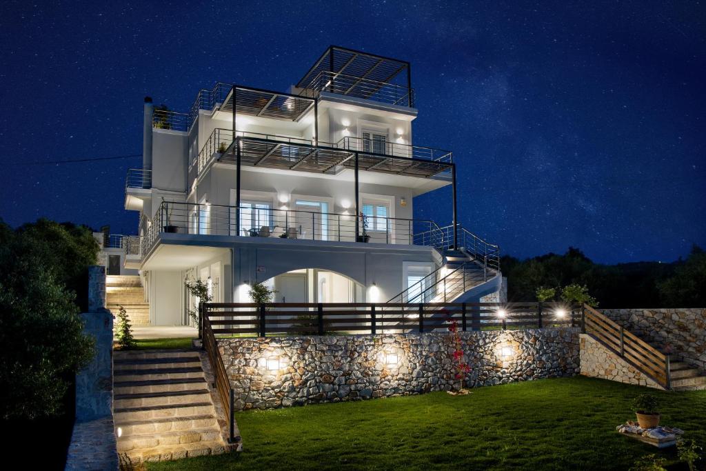 a large white house with stairs and lights at Villa Denise in Kalyves
