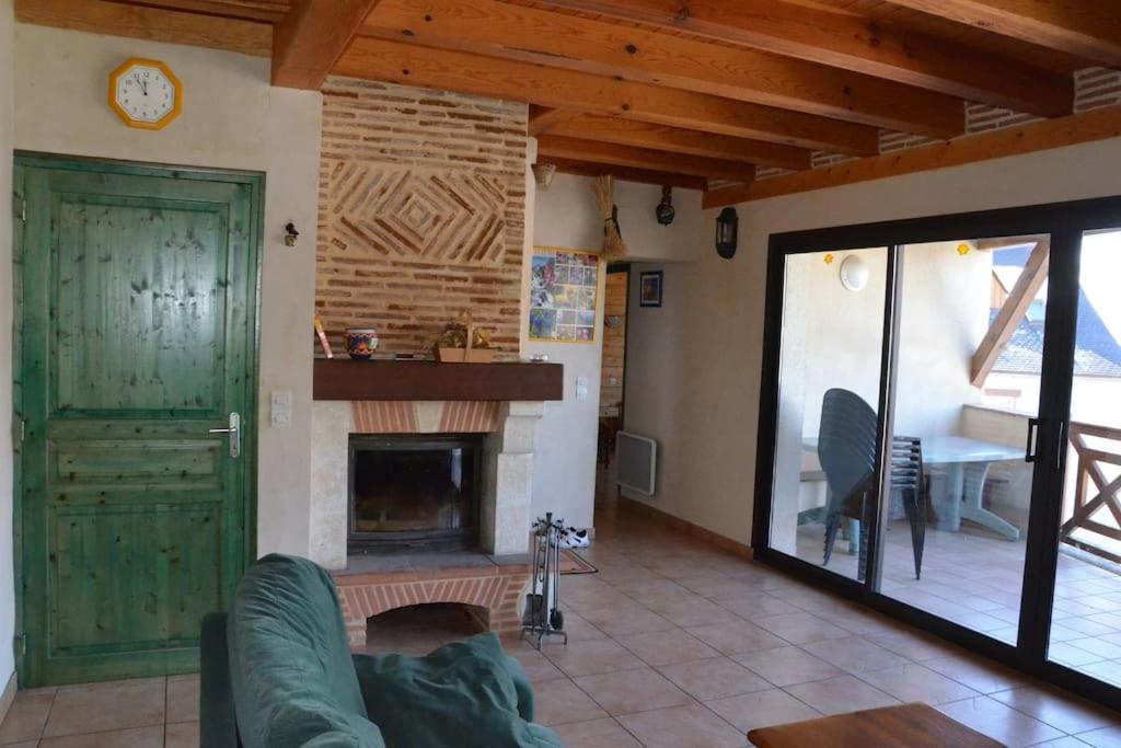 sala de estar con chimenea y puerta verde en Chalet 12 places à 5 mn St Lary, en Camparan