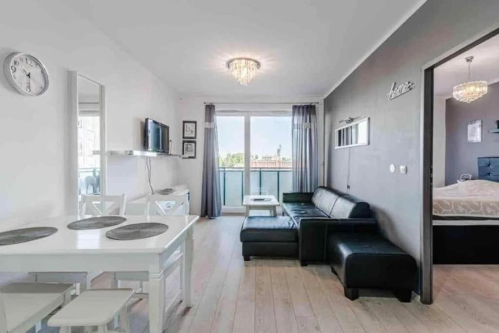 een woonkamer met een bank en een tafel bij Central Apartments & Wal25C in Gdańsk