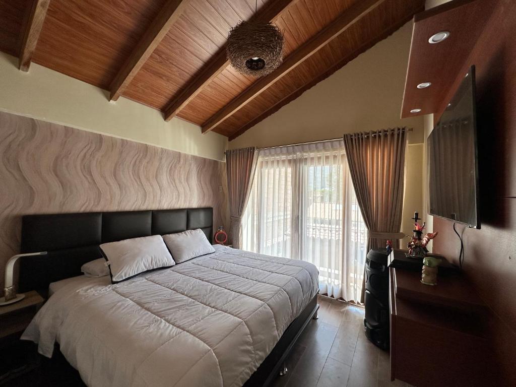 Calca的住宿－Sacred Valley House，一间卧室设有一张大床和一个大窗户