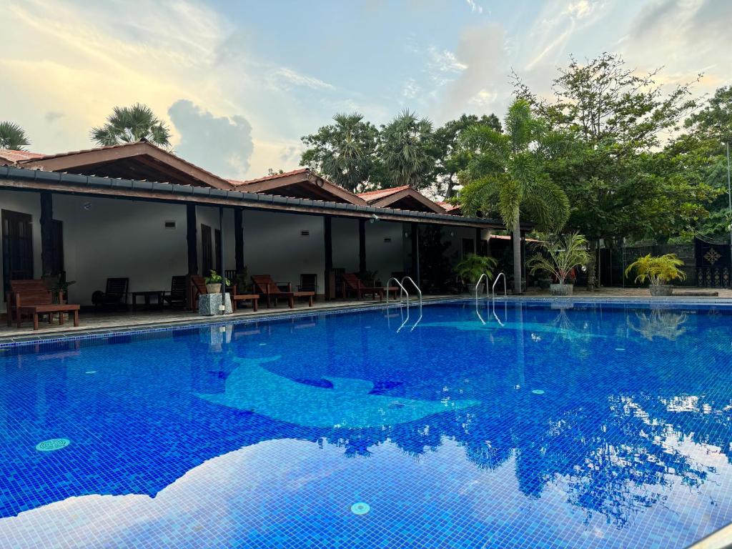 a large blue swimming pool in front of a house at Paris Garden Resort in Trincomalee