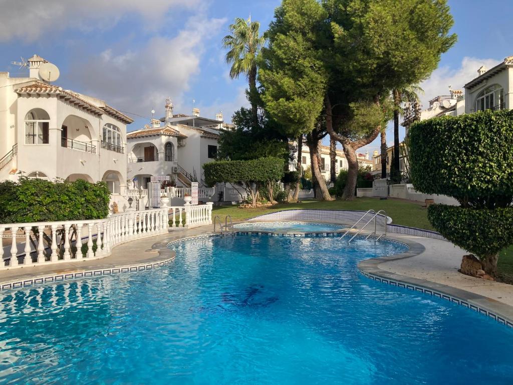 una gran piscina frente a una casa en M&M Relax apartman en Torrevieja