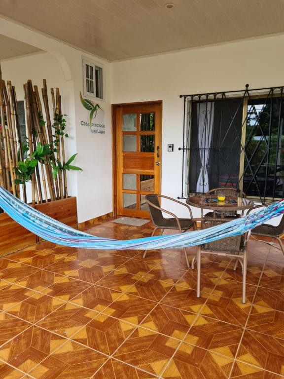 a hammock in a room with a table and chairs at Casapreciosa-LasLajas in Las Lajas