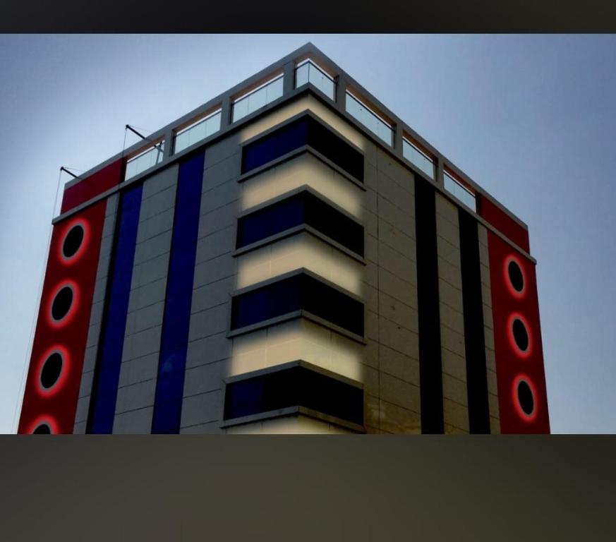 a tall building with red and blue accents at درة المكرونة للوحدات السكنية - Durrat Al-Makarona Residential Units in Jeddah