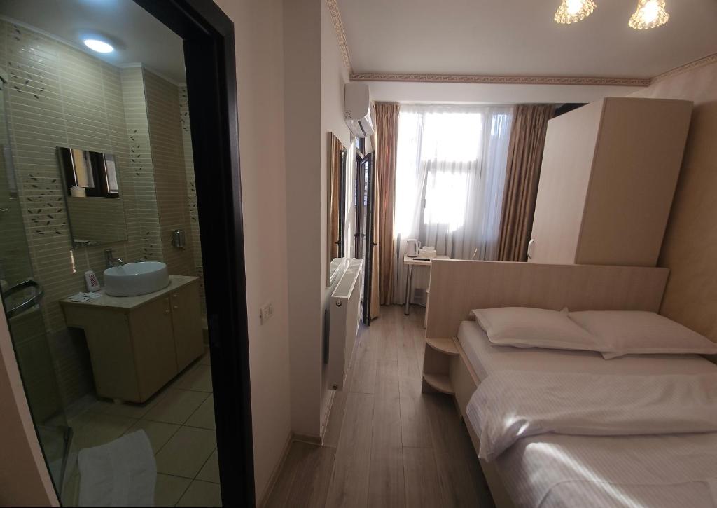 a small room with a bed and a bathroom at Hotel Marina 2 in Bucharest