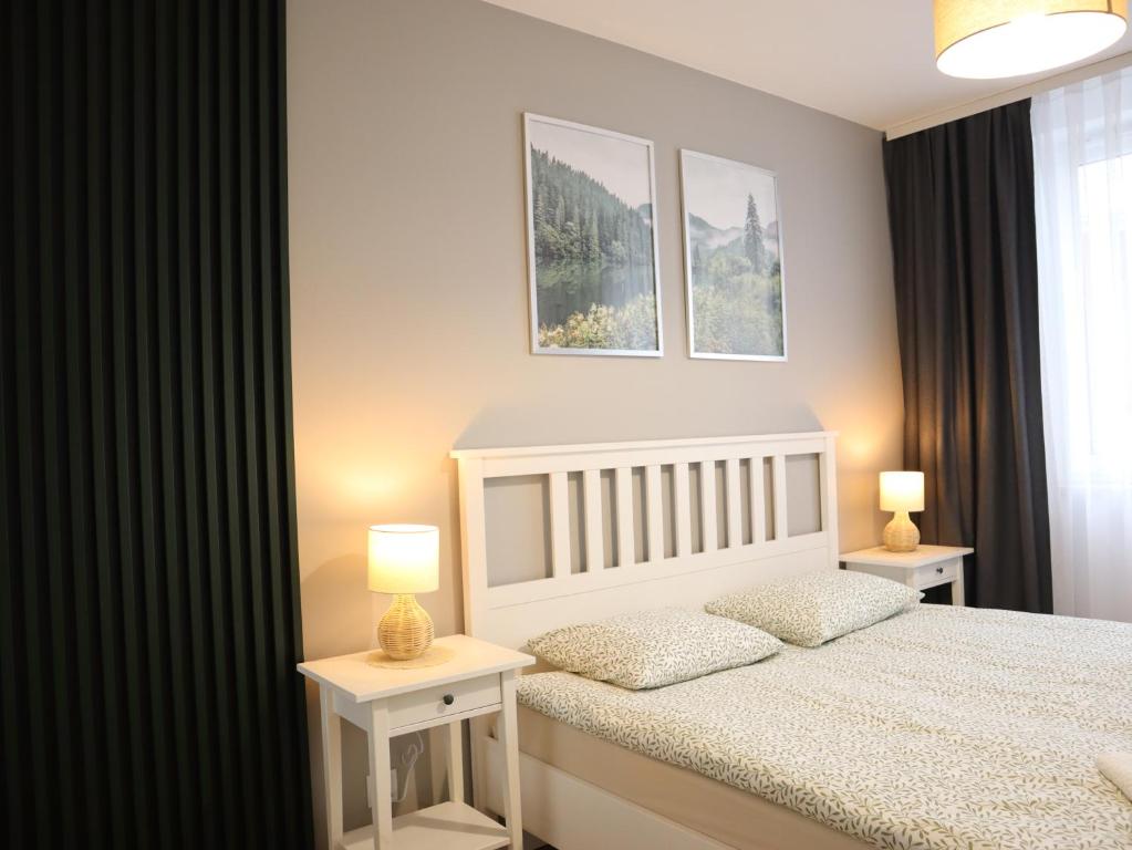 a bedroom with a white bed and two night stands at Apartament Nowy Sącz in Nowy Sącz