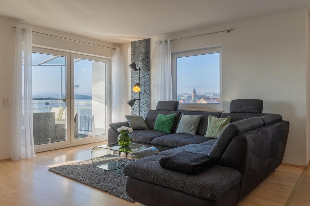 DornstettenにあるCloudCabins Dornstetten - Brunnenbergのソファと大きな窓のあるリビングルーム