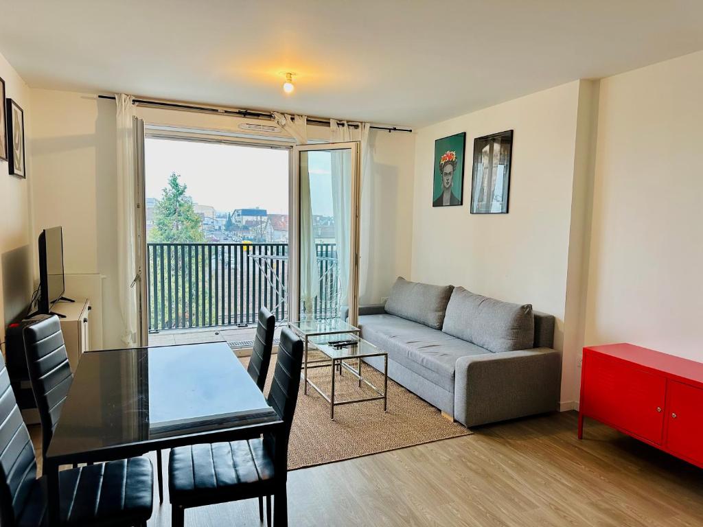 uma sala de estar com um sofá e uma mesa em T3 65 m2 avec parking 15 mns Paris by immo kit bnb em Gagny