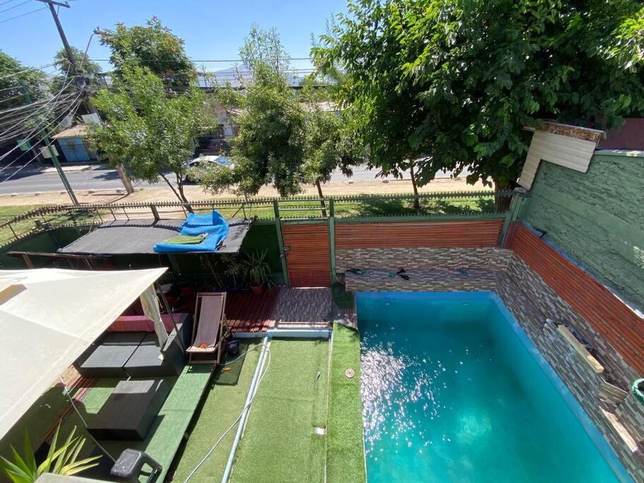 a swimming pool with chairs next to a building at Casa a pasos de Metro Conchalí in Santiago