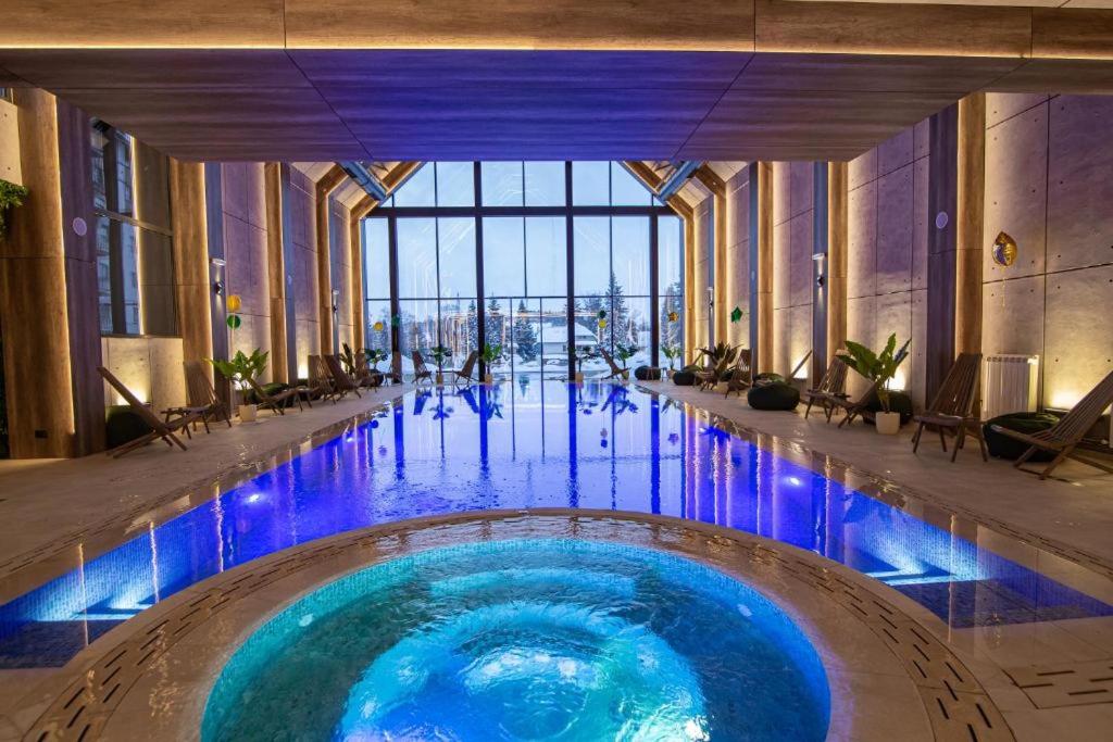 een zwembad met blauwe lichten in een gebouw bij Apartman Lux Relax nalazi se u Titovoj vili in Palisat