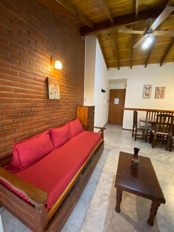 een kamer met een bed met een bakstenen muur bij LAS DACHAS 2 Villa Gesell in Villa Gesell