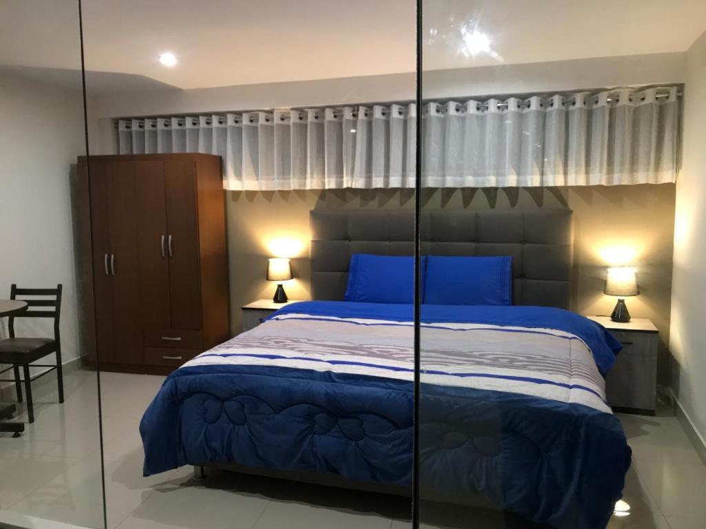 ein Schlafzimmer mit einem blauen Bett mit verspiegelten Wänden in der Unterkunft Plaza del Inka in Urubamba