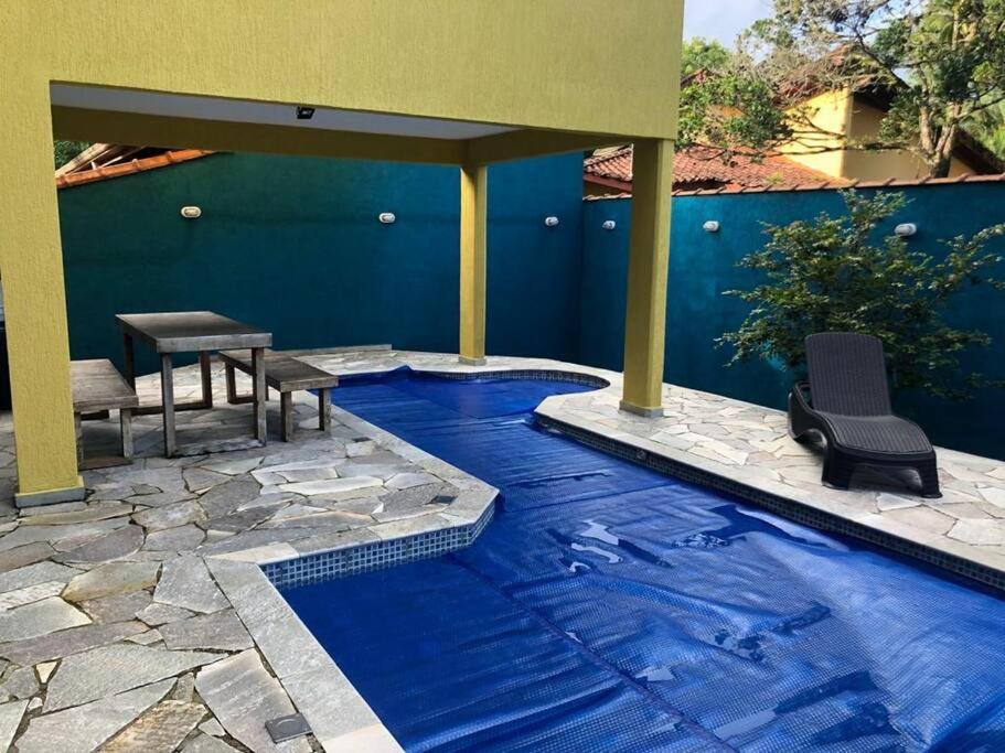 uma piscina com uma mesa e cadeiras num pátio em Sobrado c/ PISCINA na Barra do Una (Litoral Norte) em São Sebastião