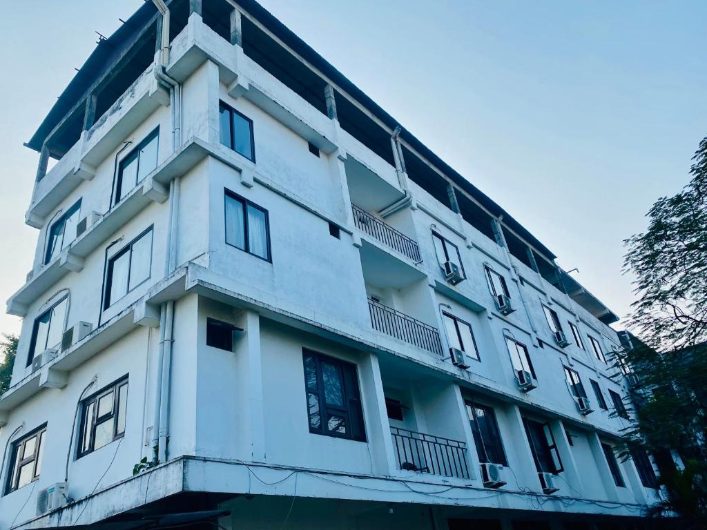 Un bâtiment blanc avec beaucoup de fenêtres dans l'établissement Hotel Sova's Inn, à Birātnagar