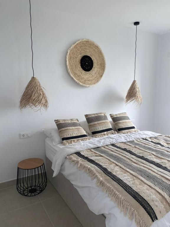 - une chambre avec des murs blancs et un lit avec des oreillers dans l'établissement La casa del león dormido, à Polop