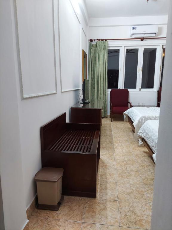 a bedroom with a bed and a desk with a television at Khách Sạn Trung Mai in Ho Chi Minh City