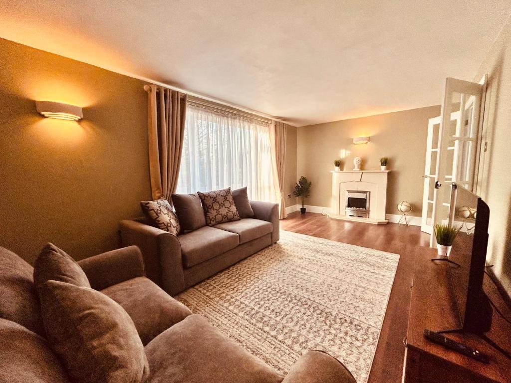 a living room with a couch and a fireplace at Stunning 3BR House w/ Parking in Stevenage