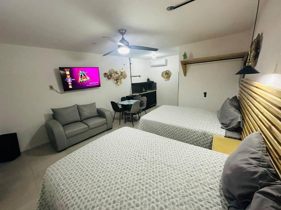 a hotel room with two beds and a couch at Departamento 2 camas in Matamoros