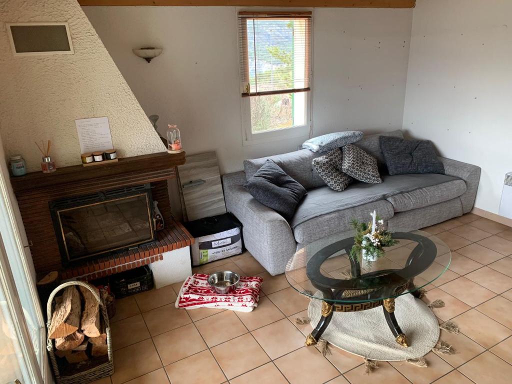 Maison de montagne au bord du lac في Le Sauze-du-Lac: غرفة معيشة مع أريكة ومدفأة