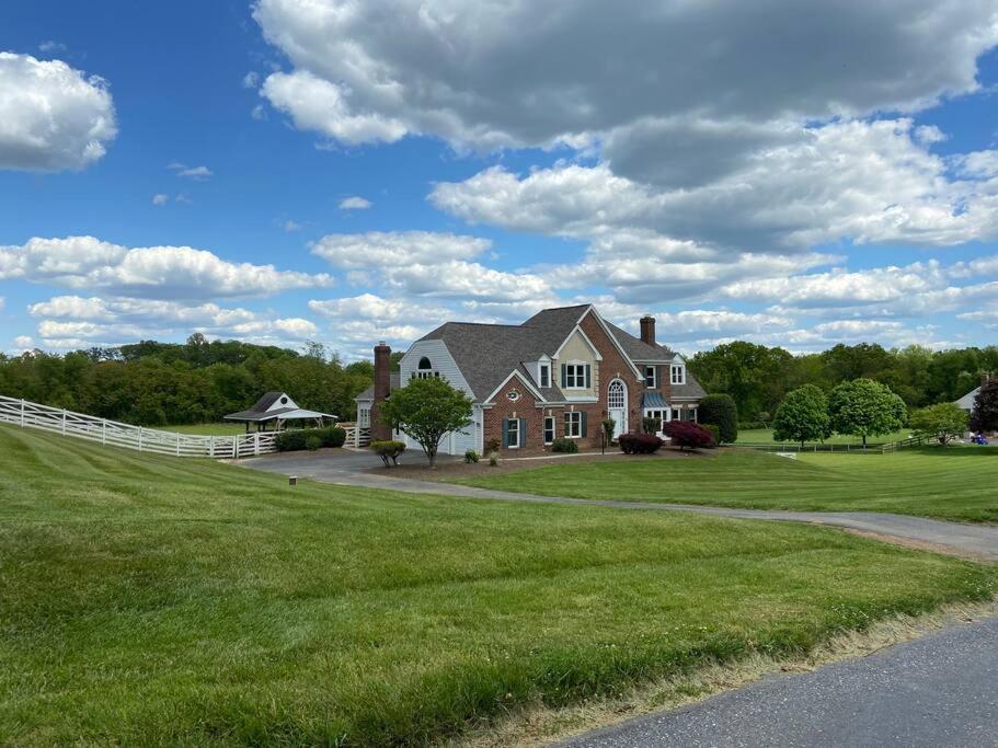 a large house on a grass field with a road at The Retreat at Davis Mill in Germantown