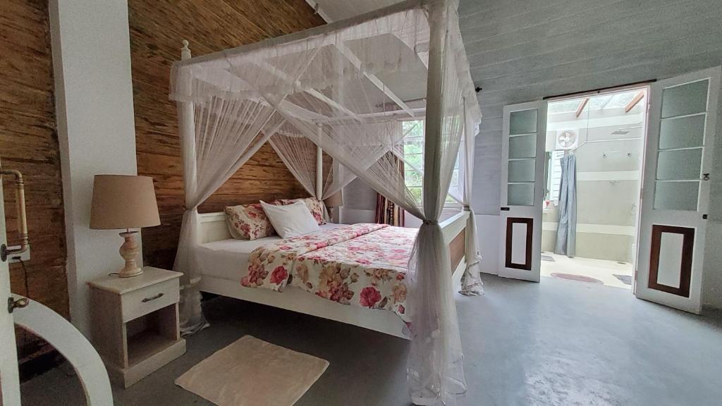 a bedroom with a bed with a canopy at Walauwa on the hill in Hatton