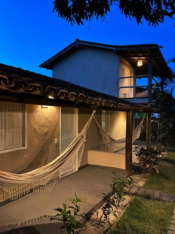 uma casa com uma rede na frente em Pousada Amora Caraiva em Caraíva