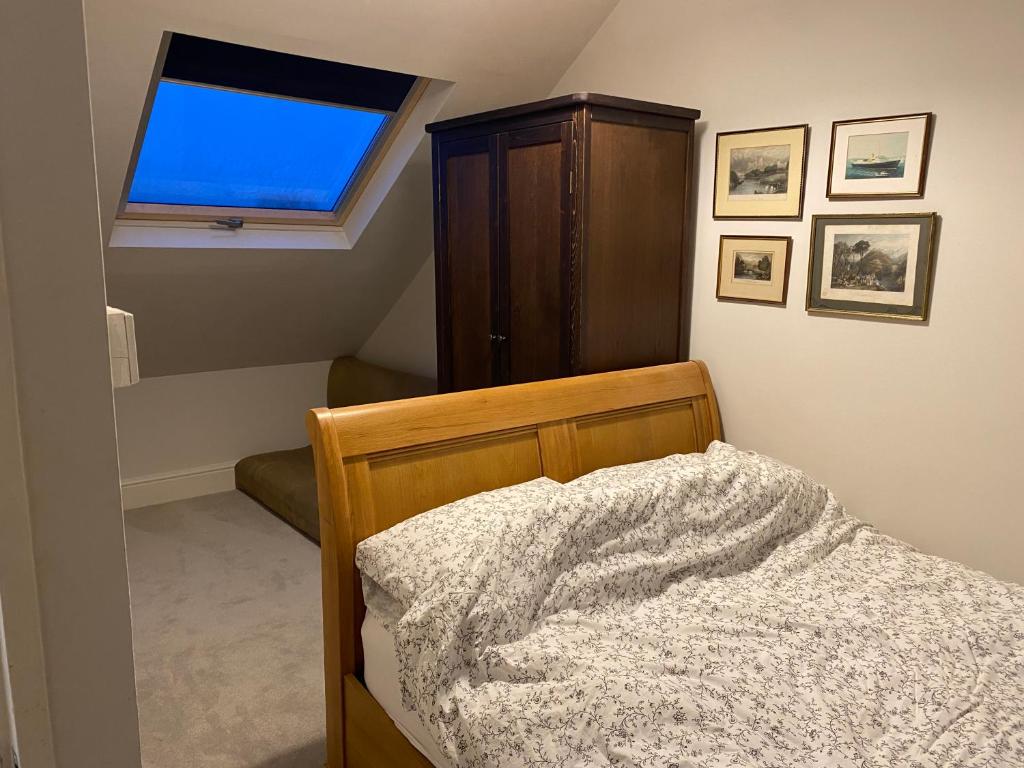 a bedroom with a bed with a dresser and a window at Castle View in Windsor