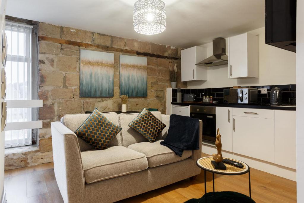 sala de estar con sofá y cocina en Cute Duplex Apartment in Leeds en Kirkstall