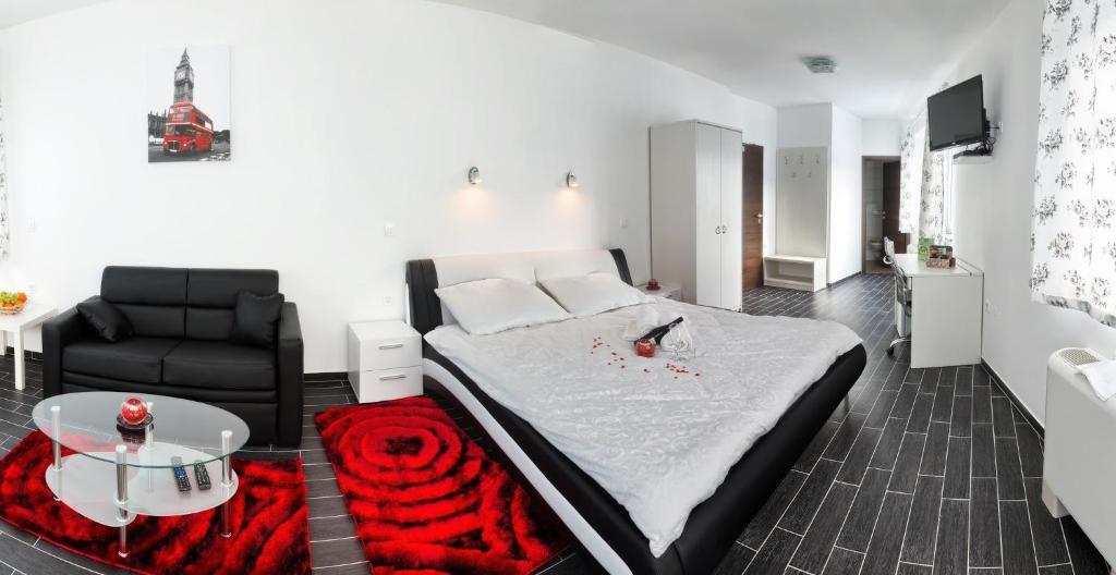 馬里博爾的住宿－格里伊蘭卡波德博霍約姆酒店，一间卧室配有一张床、一张沙发和一张桌子