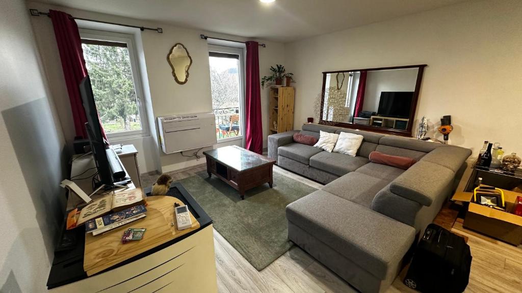 een woonkamer met een bank en een tv bij Chez Marie en Savoie in La Ravoire