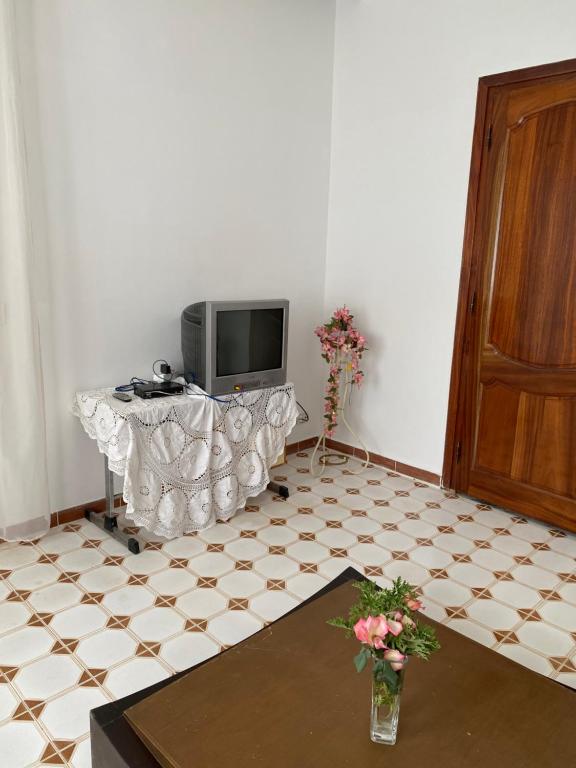 a living room with a television and a tiled floor at Slama in Nabeul