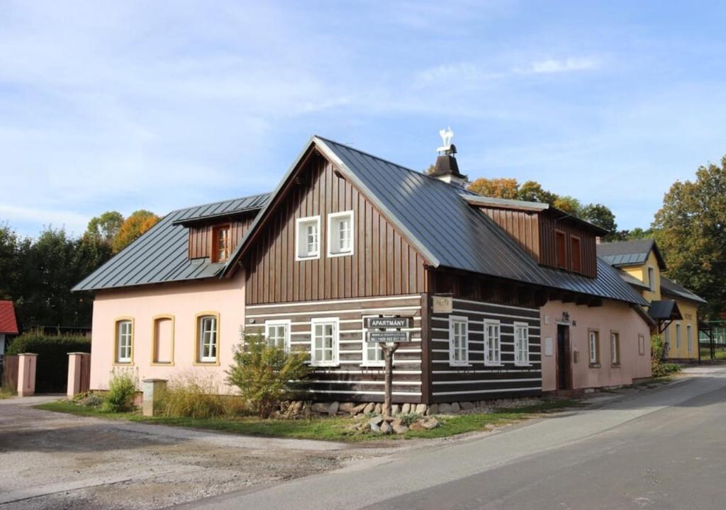 a wooden house with a black roof at Krkonošská chaloupka in Cerny Dul