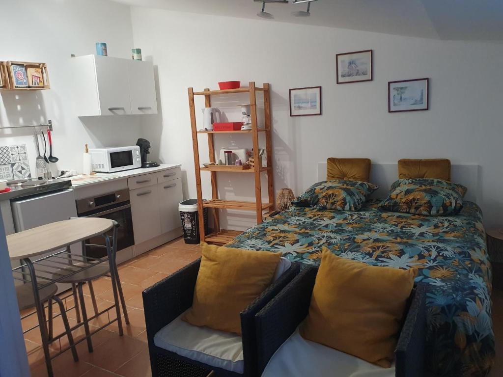 sypialnia z łóżkiem i stołem oraz kuchnia w obiekcie Studio Diadéma Armor w mieście Plérin