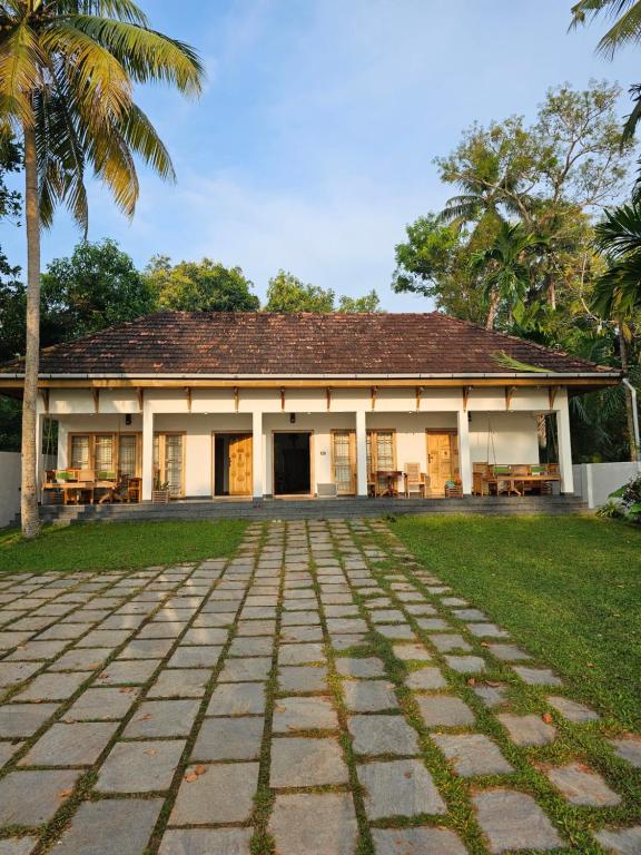 a building with a palm tree in front of it at Lake facing Villa-Water sport activities-Niva Waterways in Vaikom