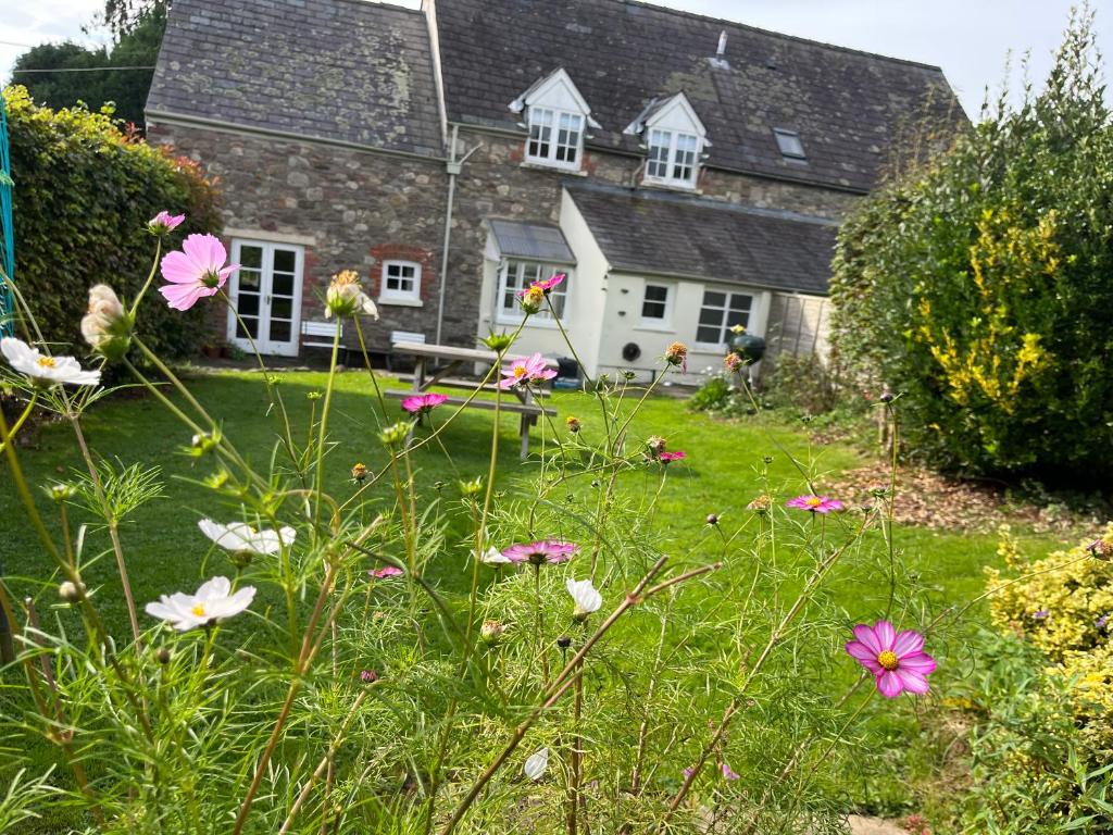 un jardín con flores frente a una casa en The Cottage en Abergavenny