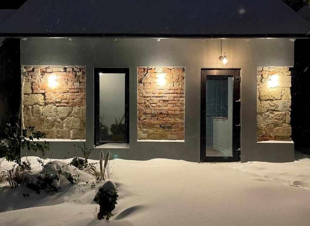 une maison avec de la neige devant elle et deux miroirs dans l'établissement Tiny Barn House, à Chişinău