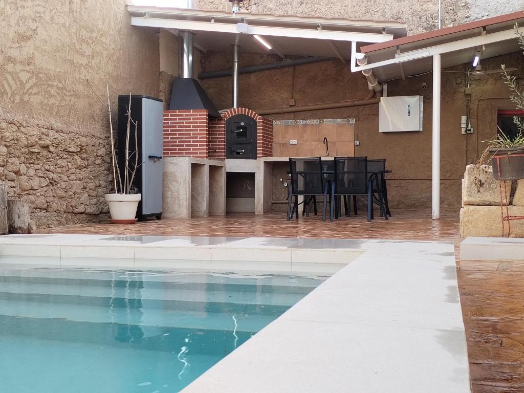 an outdoor kitchen and dining area in a building with a swimming pool at CASA MOYA-LA ENCARNACIÓN in Caravaca de la Cruz