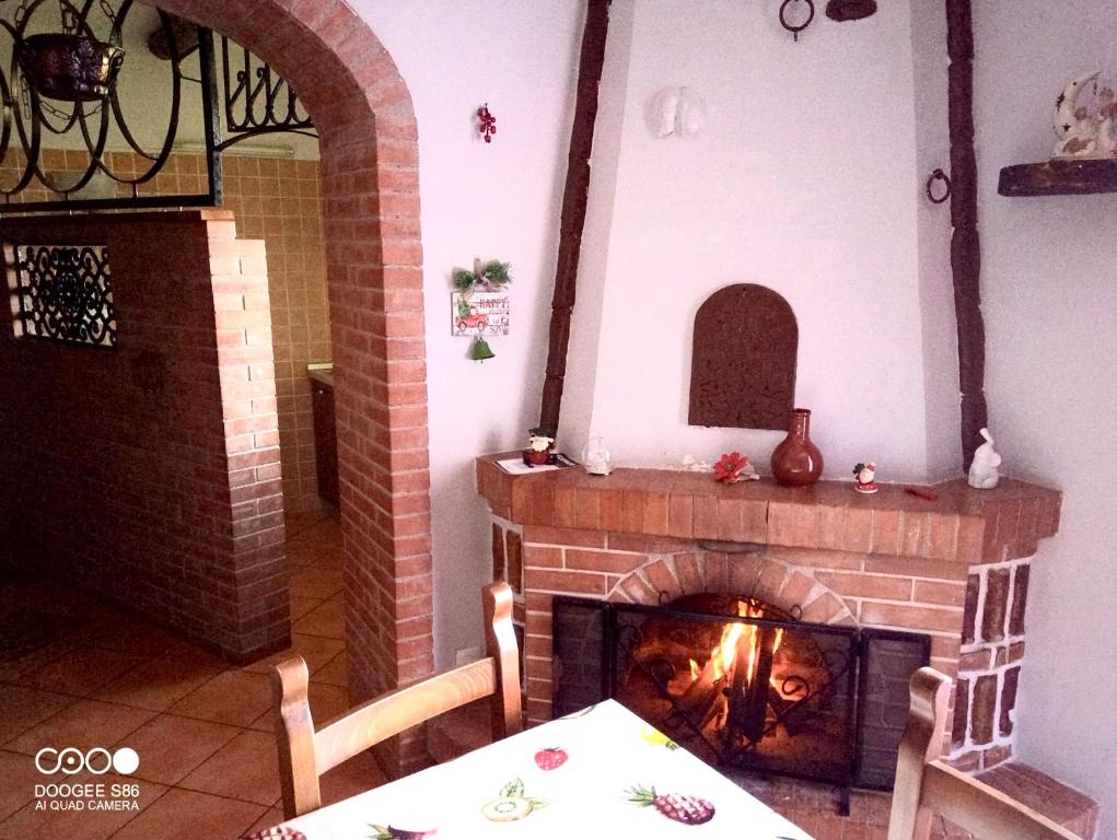 a living room with a brick fireplace with a table and a table at La casa del Nonno in Altavilla Irpina