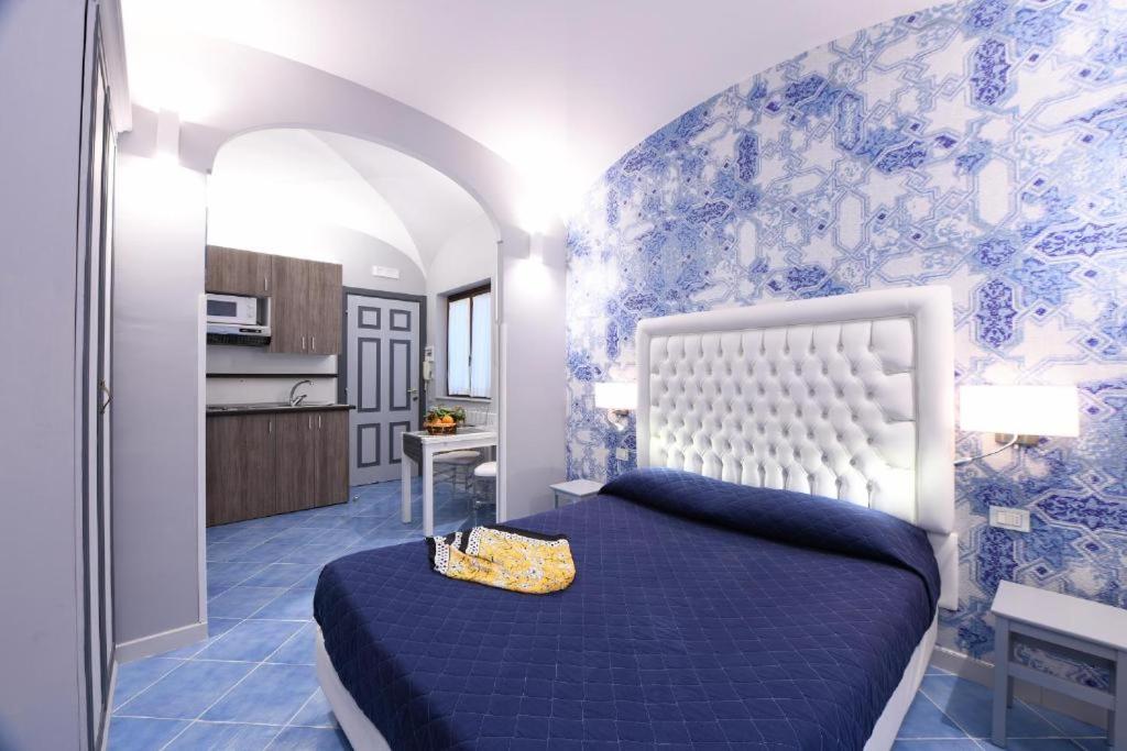 - une chambre bleue et blanche avec un lit et une cuisine dans l'établissement La Casa ad Amalfi centro storico, à Amalfi