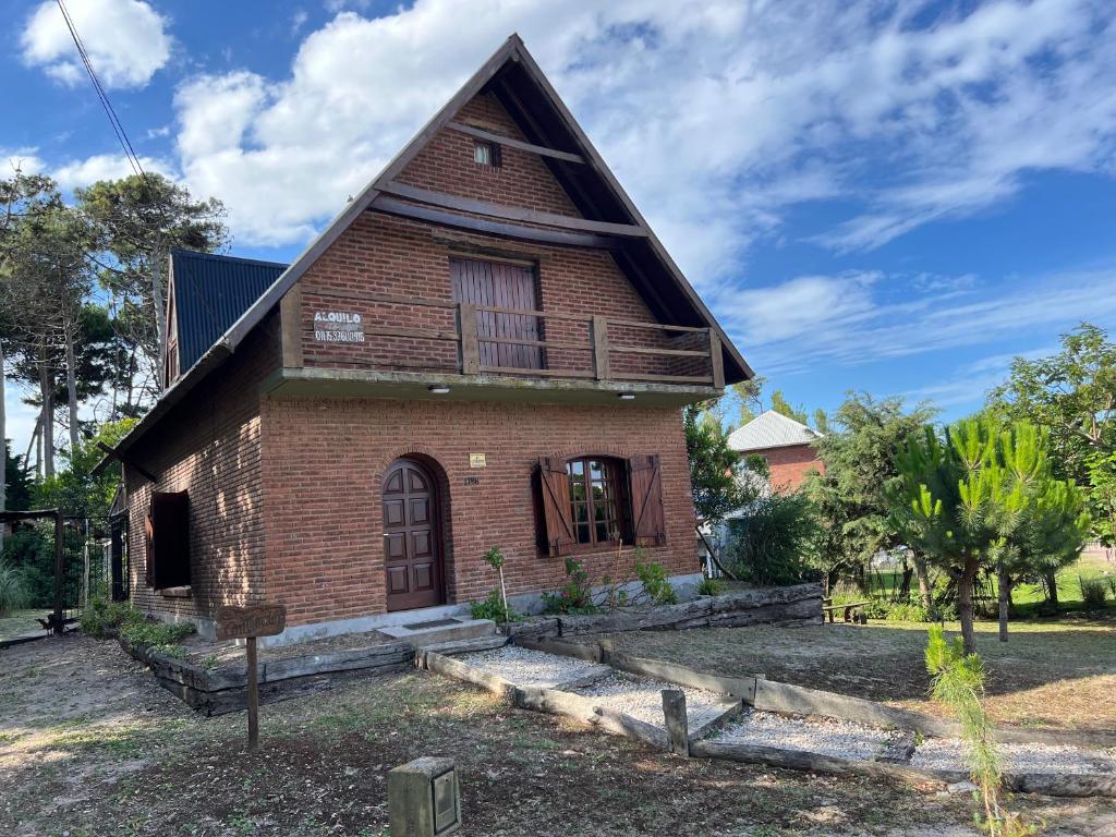 una vieja casa de ladrillo con techo de gambrel en La Contención en Balneario Mar Azul