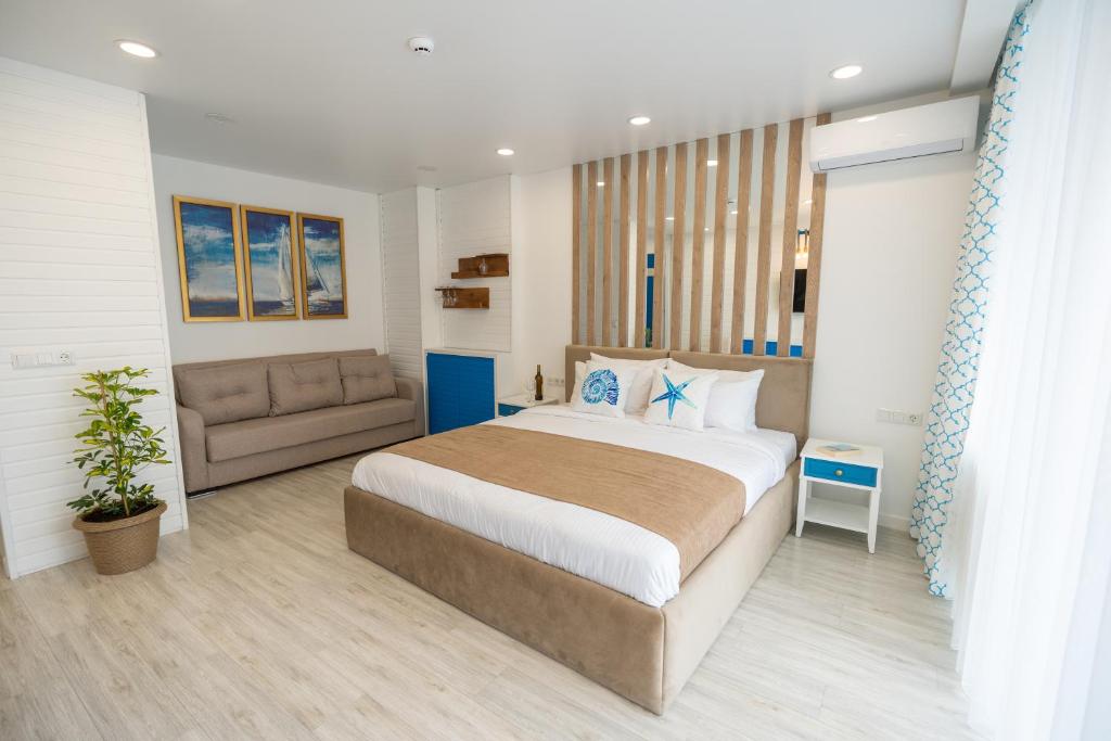 um quarto com uma cama grande e um sofá em Seagull Beachfront Boutique Hotel em Batumi